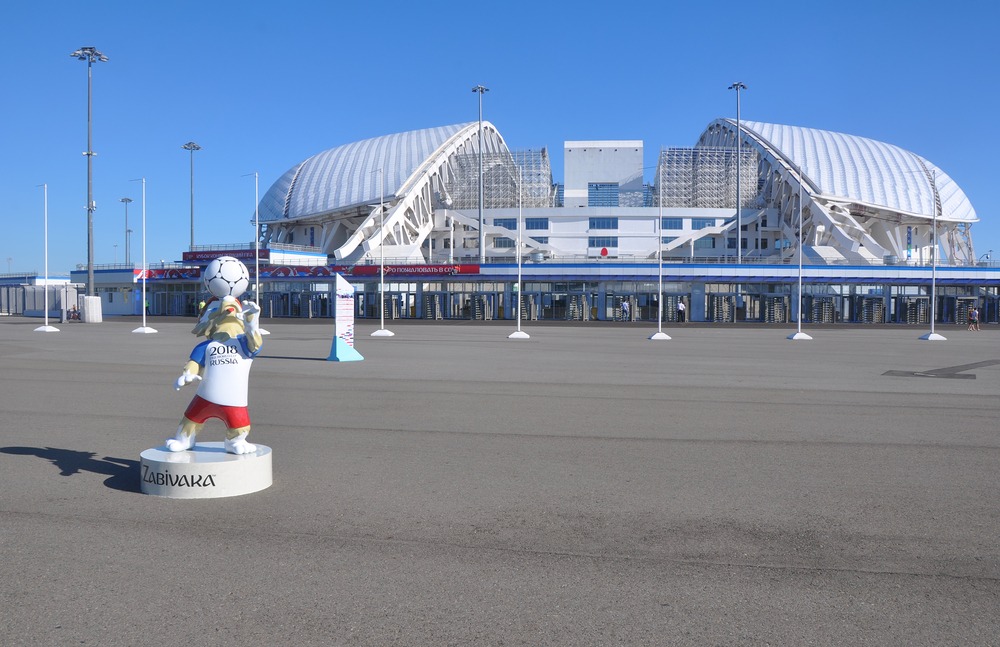 Det olympiske stadion i Sotji set udefra. I forgrunden ses en statue af VM-maskotten Zabivaka.