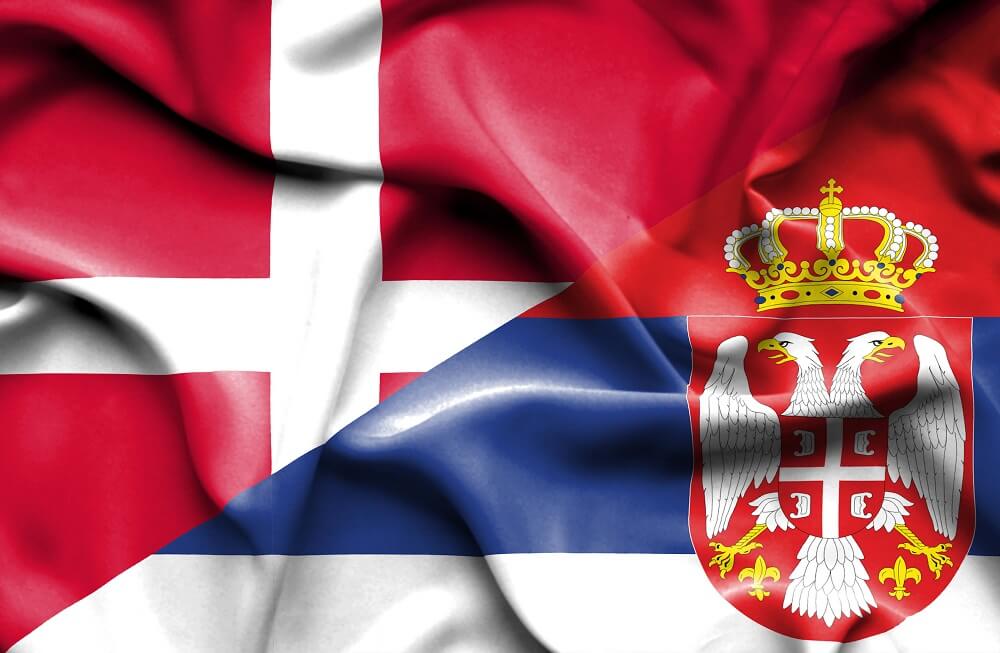 Det danske og serbiske flag som blafrer i vinden